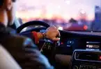 man driving a car wearing wrist watch