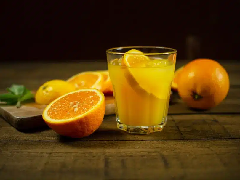 orange juice in clear drinking glass